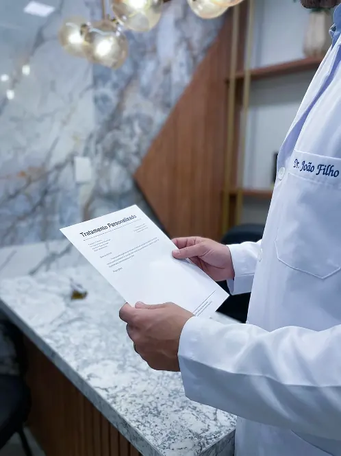 Médico segurando a prescrição do tratamento